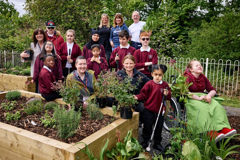 A group of disabled children with members of staff at the sensory garden