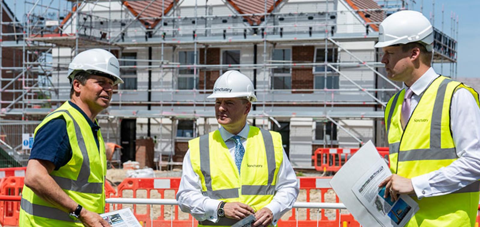 Craig Moule, Nigel Huddleston and Mark Battin in high vis jackets standing in front of the Evesham development.