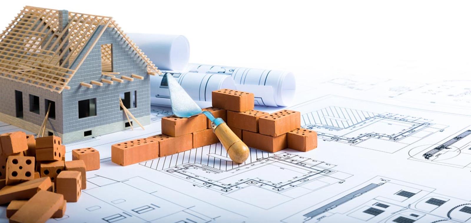 Staged image of a model home with building materials around on top of building plans