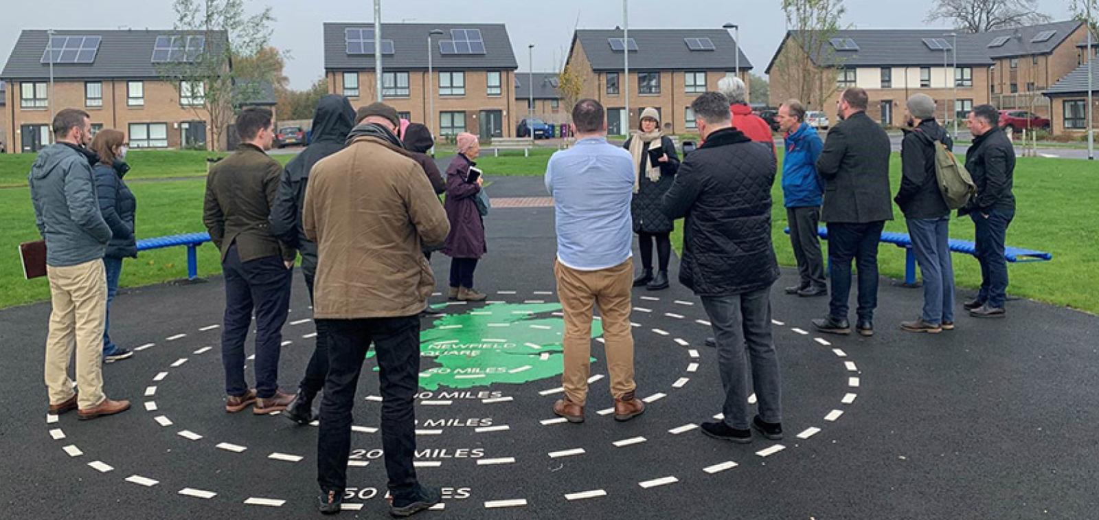 A group of local people listening to a speaker at the Newfield Square development