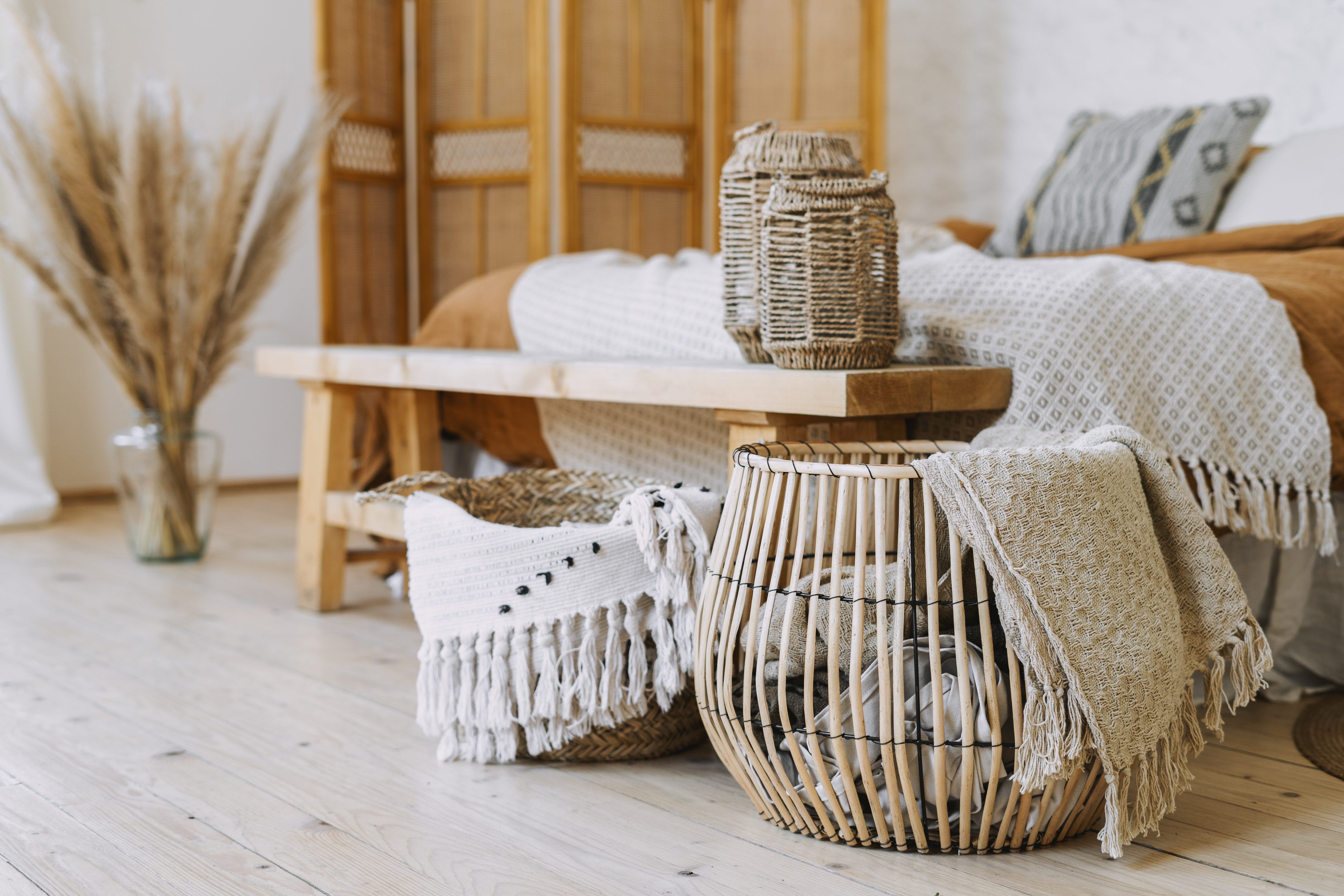A cozy room featuring a bed, a wooden table, and a basket, creating a warm and inviting atmosphere.