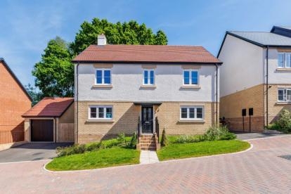 Modern two-story detached home with red-tiled roof, white and beige exterior, landscaped front garden, paved driveway, and attached garage in a residential neighborhood.