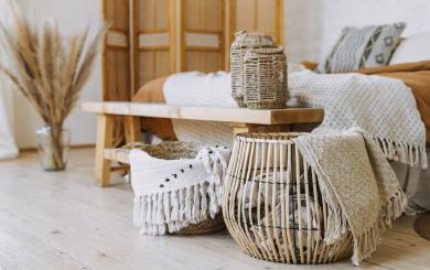 A cozy room featuring a bed, a wooden table, and a basket, creating a warm and inviting atmosphere.