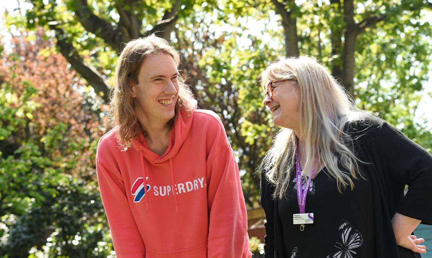 Customer and staff member smiling out in the gardens