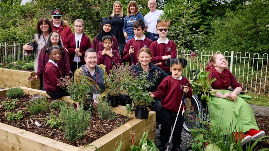 A group of disabled children with members of staff at the sensory garden
