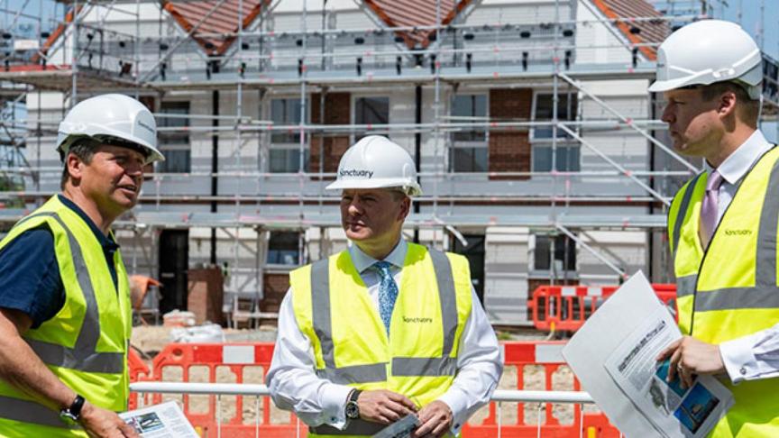 Craig Moule, Nigel Huddleston and Mark Battin in high vis jackets standing in front of the Evesham development.
