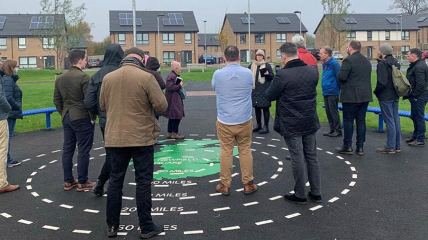 A group of local people listening to a speaker at the Newfield Square development