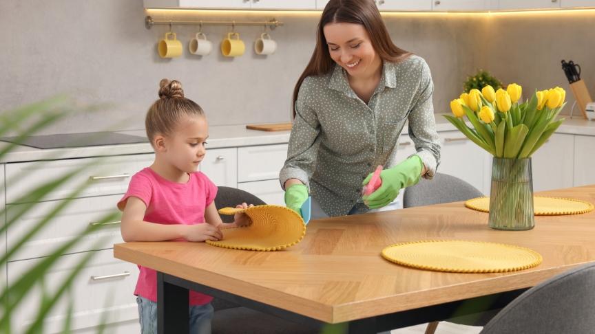 A mother and daughter cleaning their kitchen